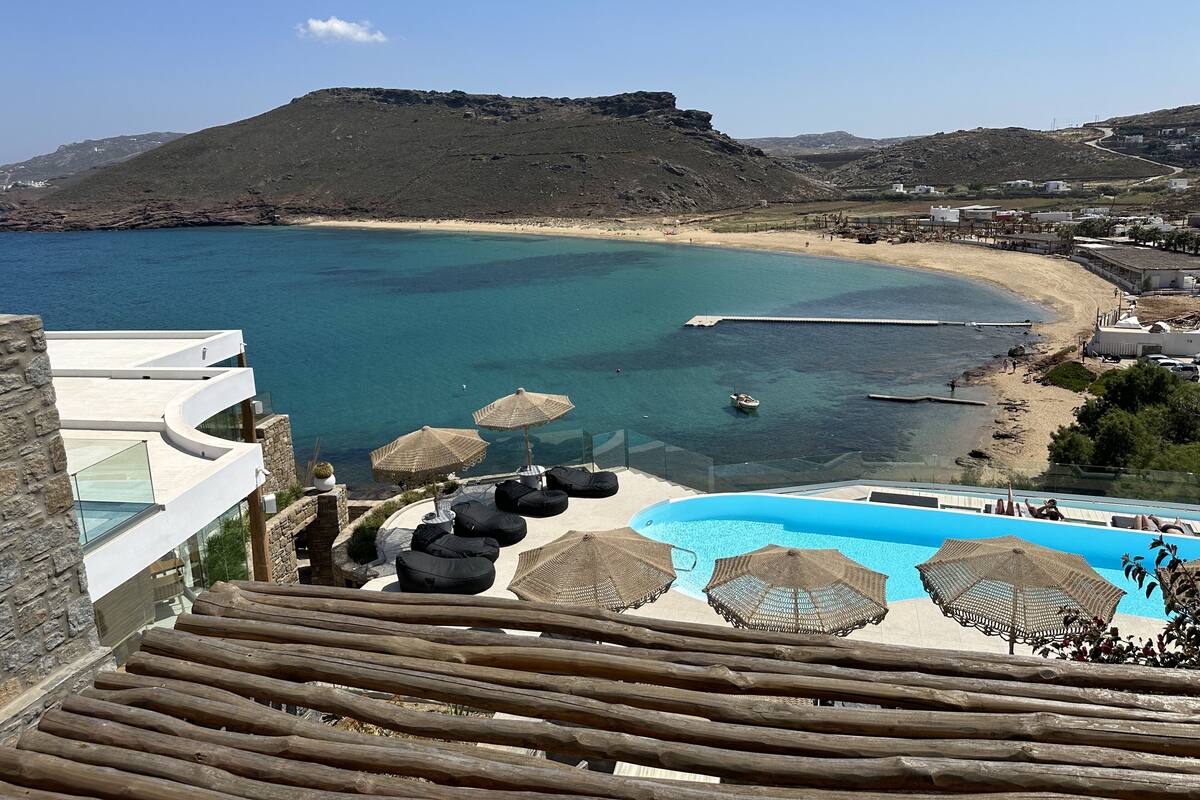 A coastal resort with a pool, beach, and mountain views.
