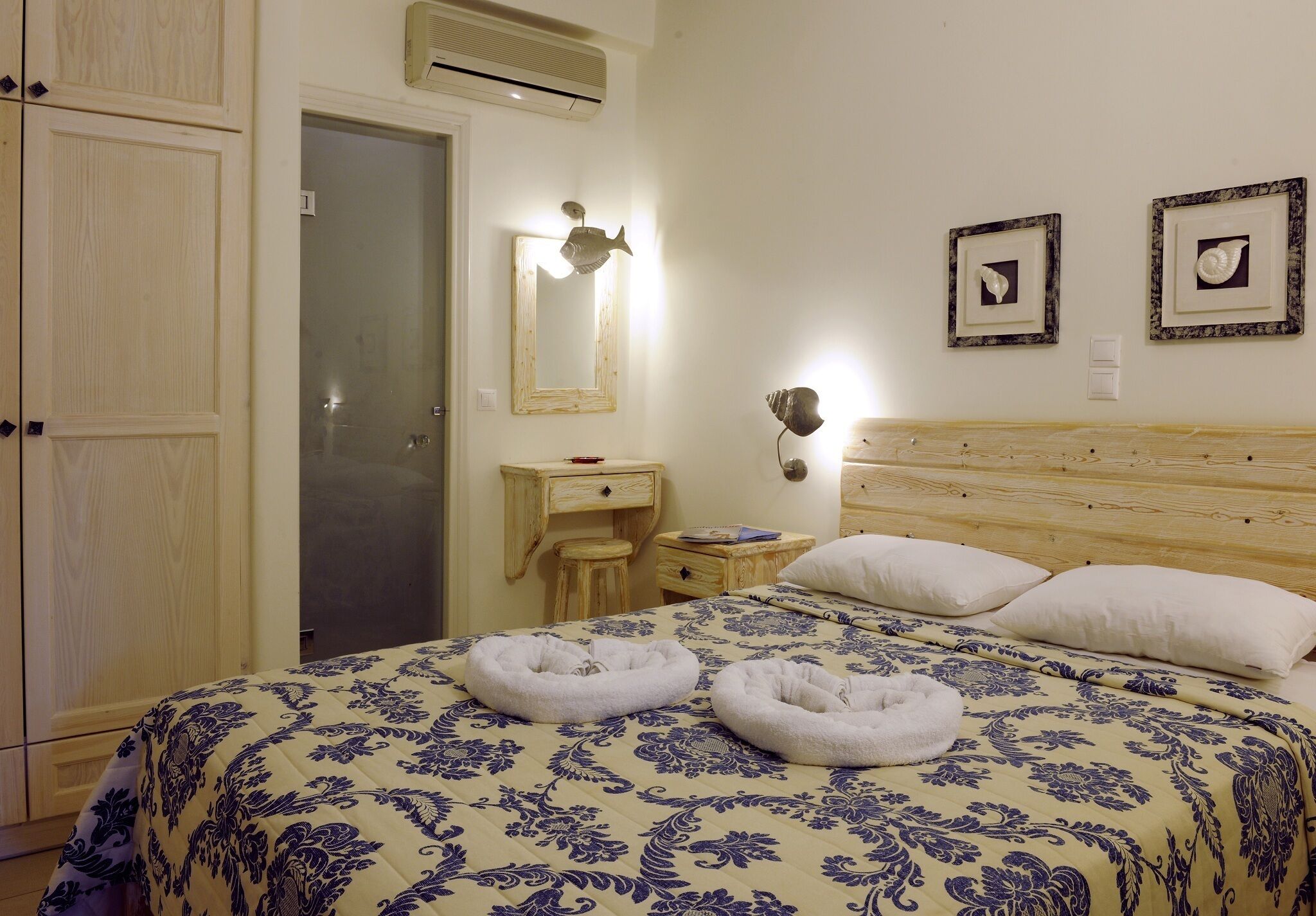 A bedroom with a bed, two bedside tables, a nightstand, a mirror, and a wardrobe.