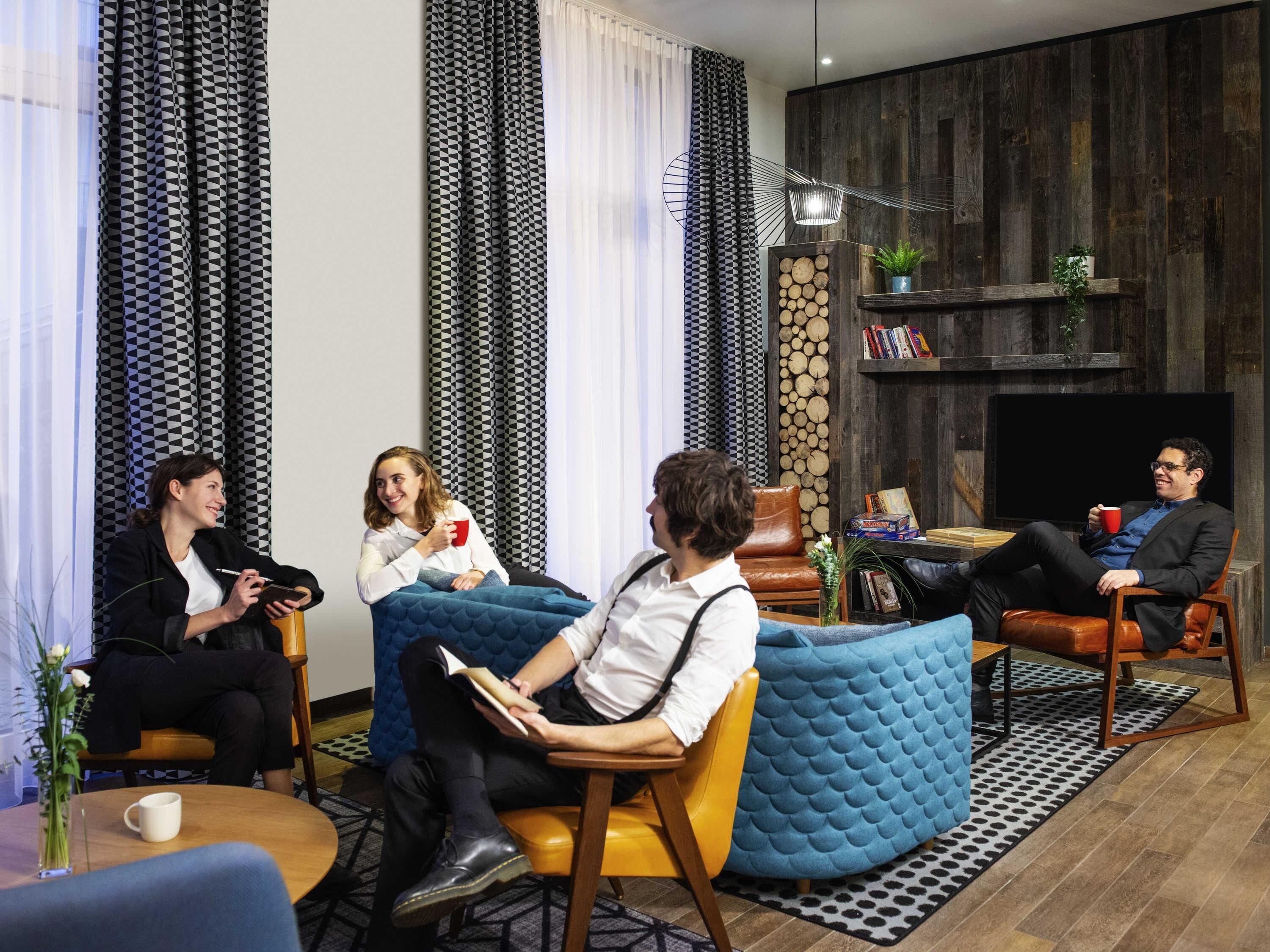 A modern living room with a fireplace, leather sofas, and a coffee table.