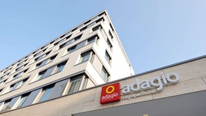 Ein modernes Gebäude mit einem Schild für 'Adagio City Apartment Hotel'.