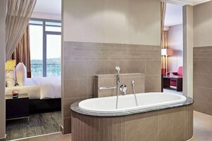 Un baño moderno con una bañera independiente, un ventanal grande y vistas al exterior.
