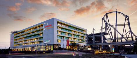 Un hotel de varios pisos con casino, noria y un diseño arquitectónico moderno.