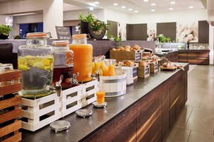 Un bufé de desayuno con diversas opciones de comida y bebidas.
