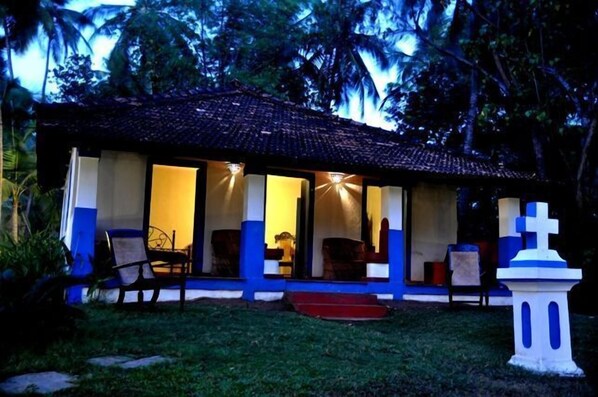 A house with a tiled roof, large windows, and a small porch area.