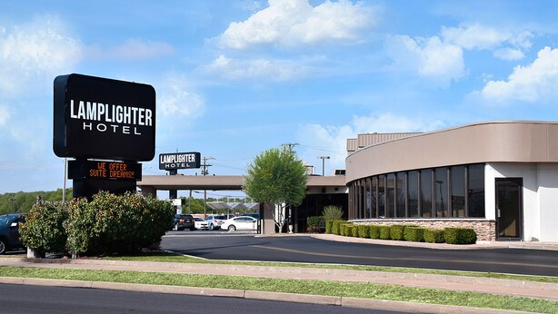A hotel entrance with a sign reading "Lamplighter Hotel."