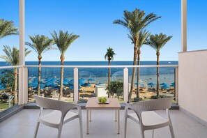 A balcony with a view of the sea, palm trees, and beach umbrellas. - Pickalbatros Royal Grand Sharm - Adults Friendly 16 Years Plus - Couples Only (Sharm El Sheikh)