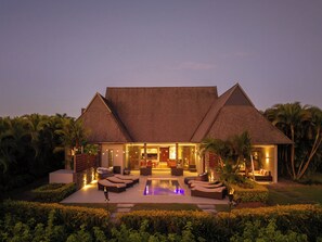 A resort with a pool, outdoor seating, and a well-lit entrance. - InterContinental Fiji Golf Resort & Spa by IHG (Natadola)