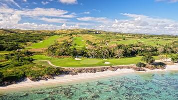 Enjoy a round of golf with a stunning view of the surrounding landscape, including a beach and ocean.