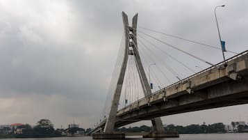 A large suspension bridge with multiple cables and a concrete deck, spanning over a body of water.