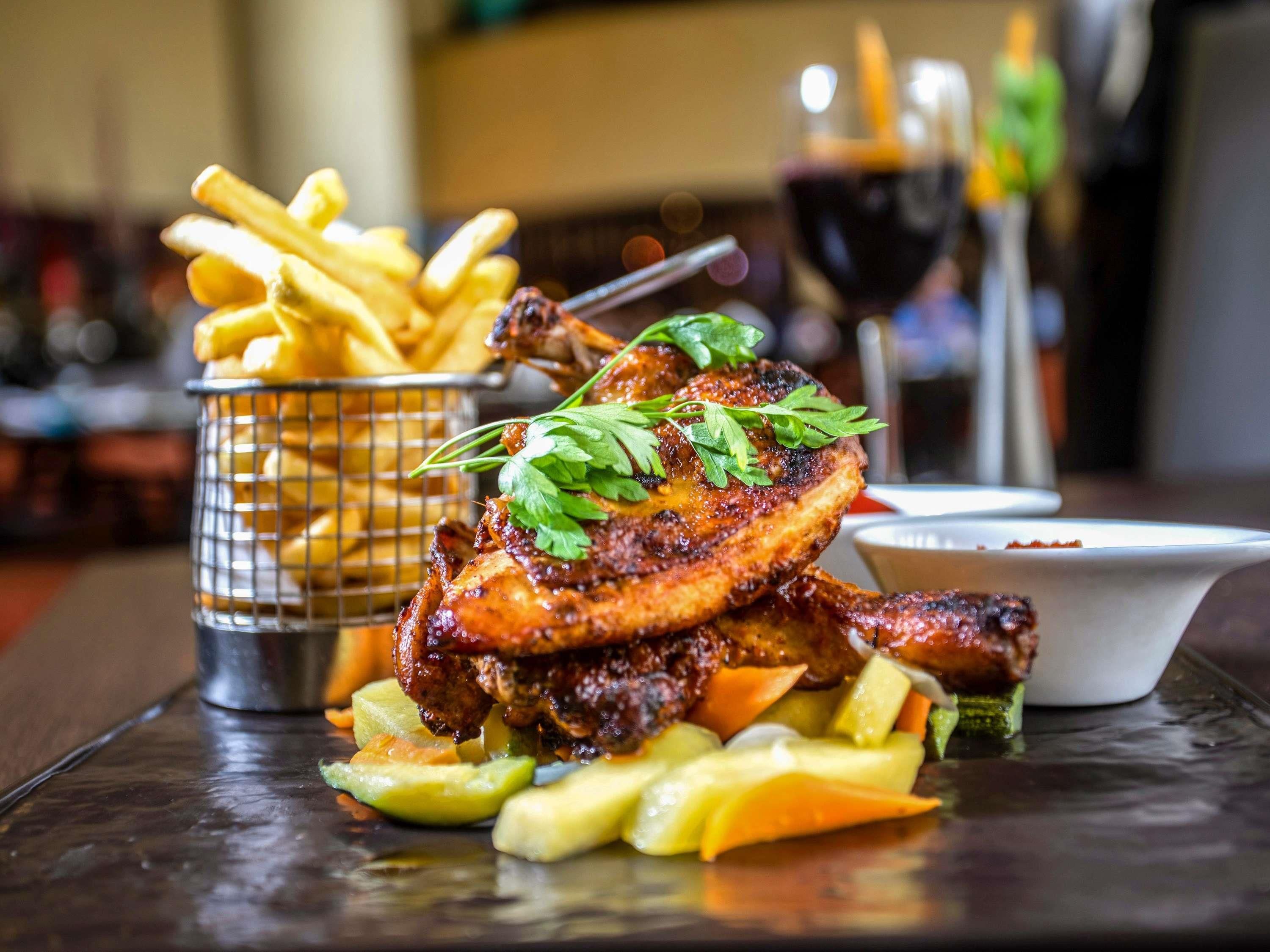 A meal with grilled meat, fries, and vegetables on a table.