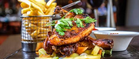 A meal with grilled meat, fries, and vegetables on a table.