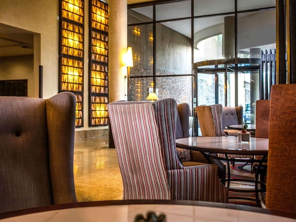 A modern lobby with a seating area, large windows, and a wall with illuminated panels. - Mövenpick Hotel Ikoyi Lagos (Lagos)