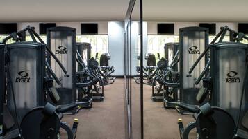 A gym with mirrored walls and multiple exercise machines labeled 'CYBEX'.