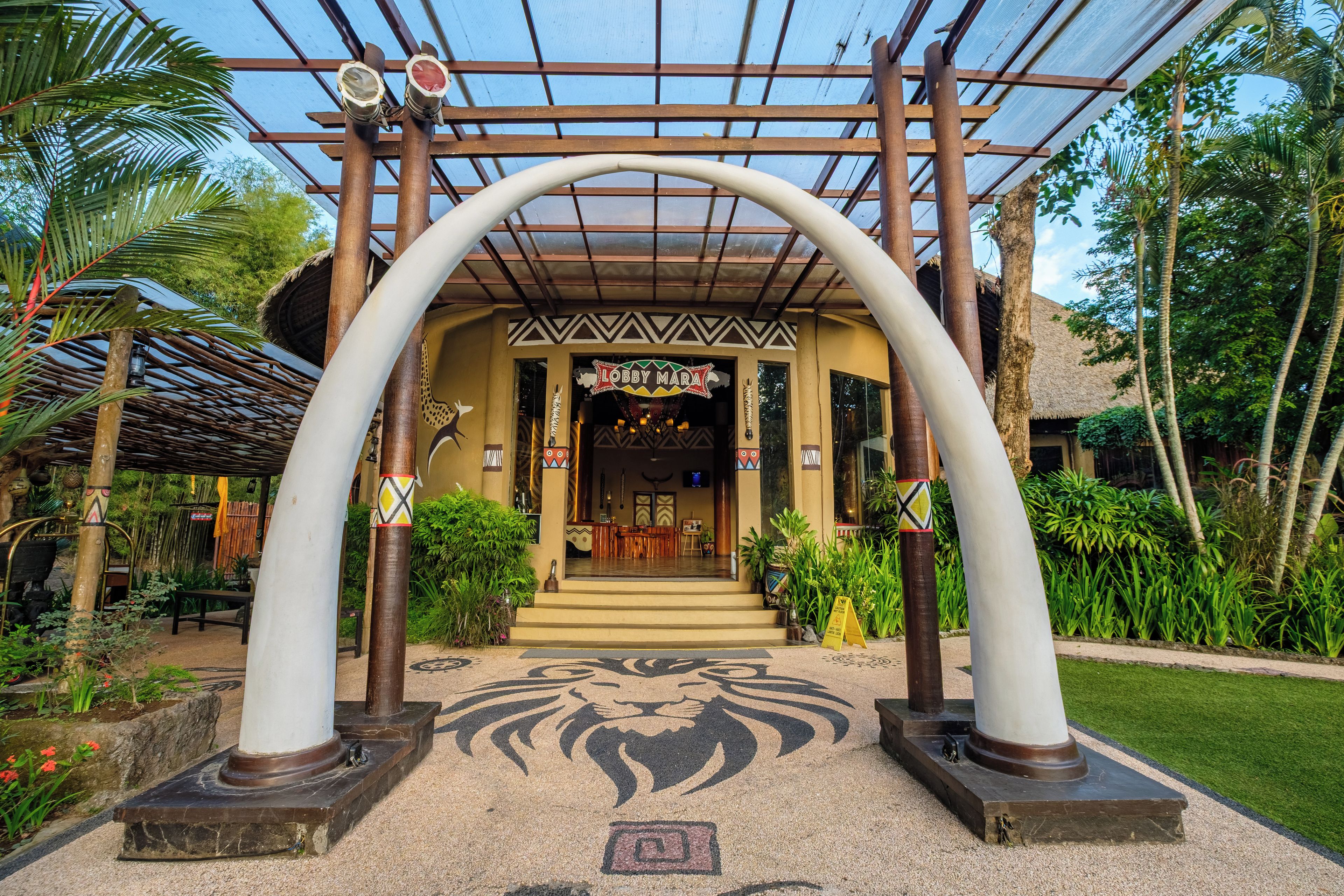 A lobby with a central archway, a reception desk, and a tropical garden.