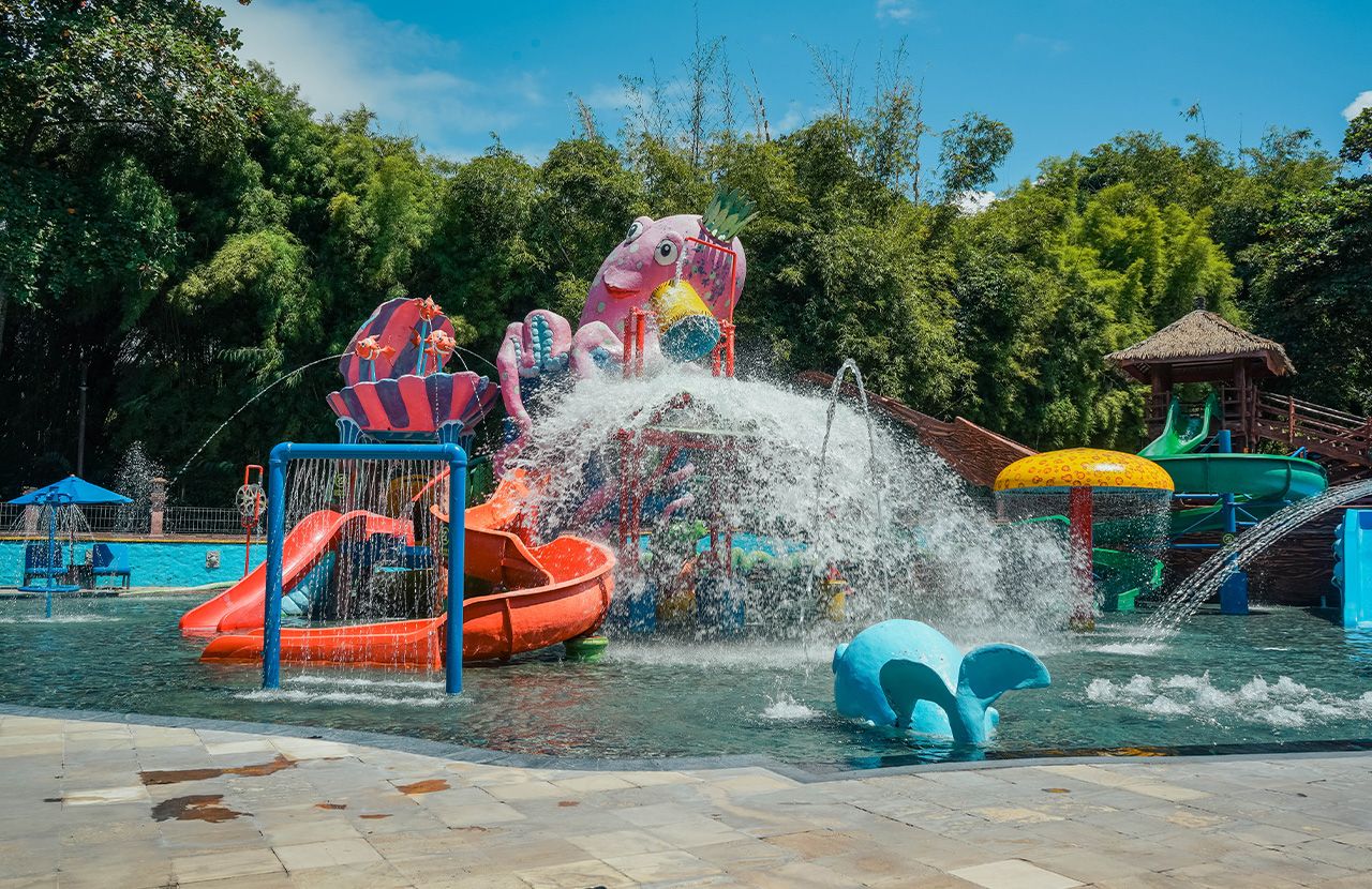 A water park with a water slide, a splash pad, and a play structure.