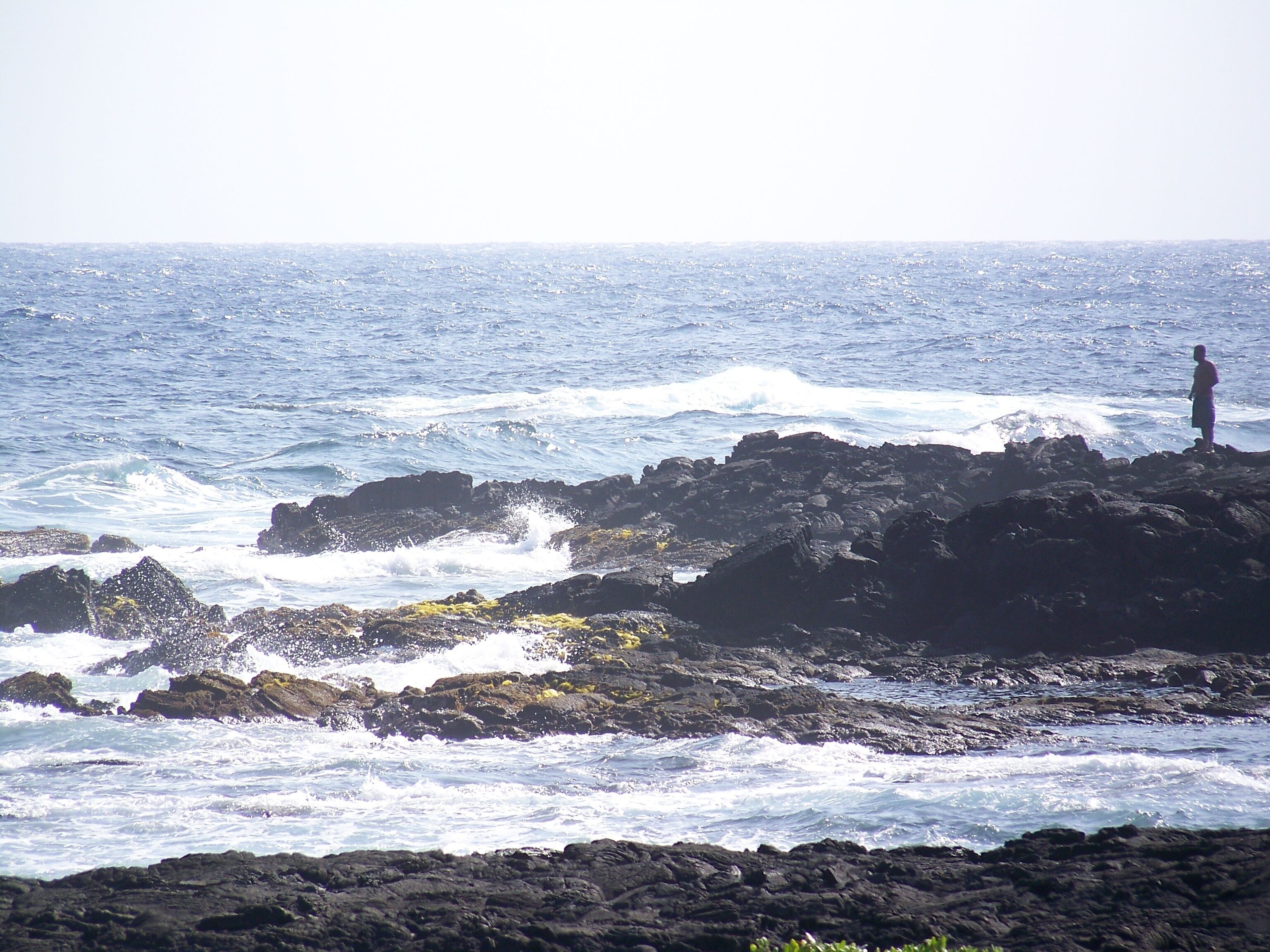 A rocky coastline with waves crashing against the rocks.