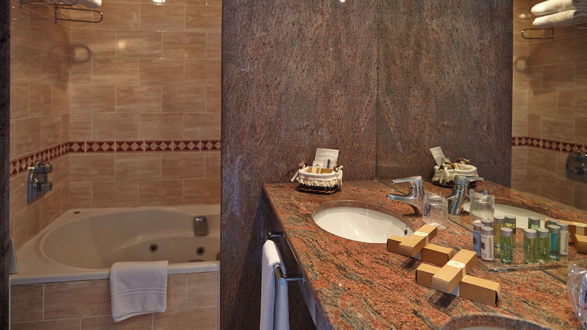 A bathroom with a bathtub, a sink, and a large mirror.
