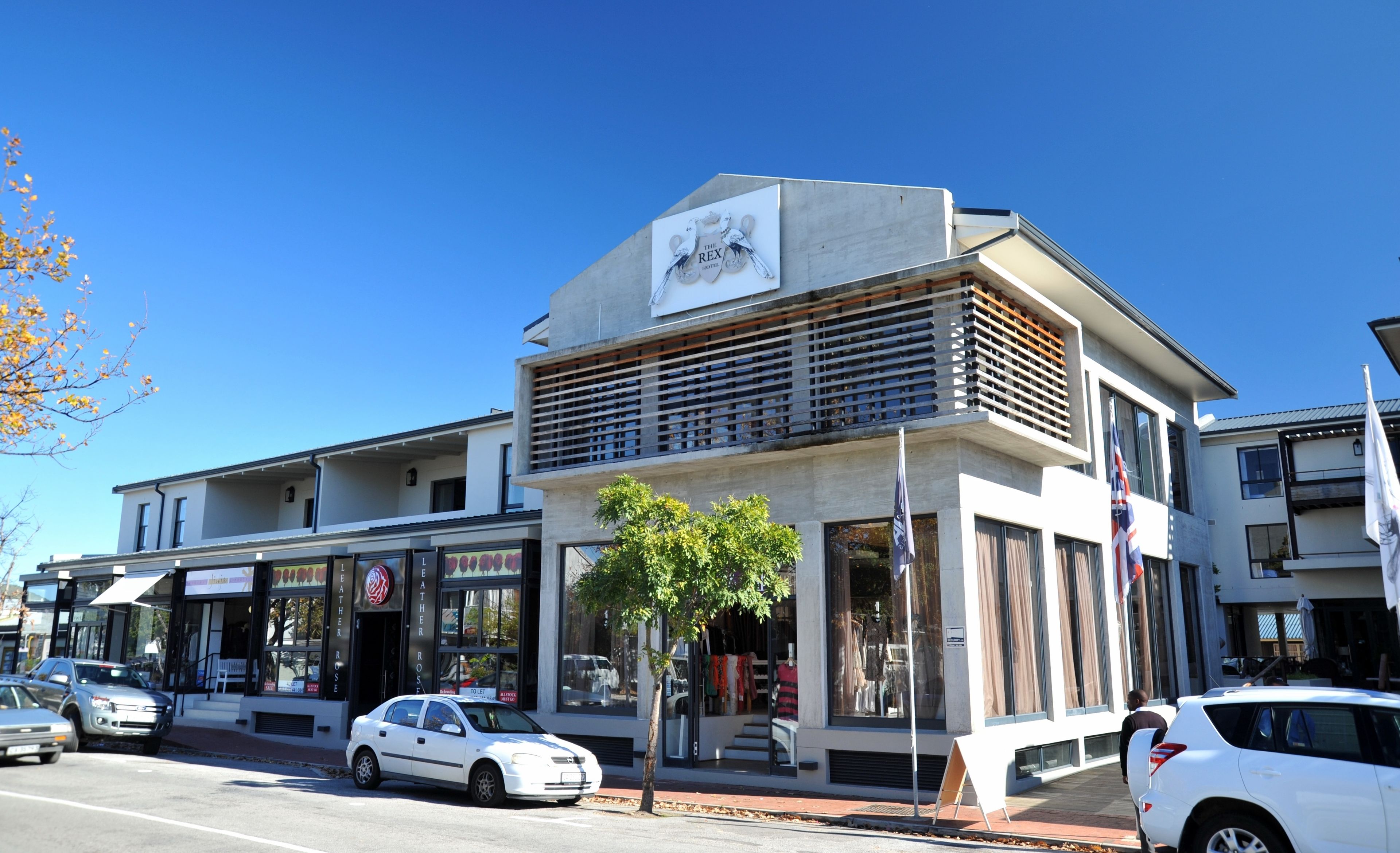 A modern building with a flat roof, large windows, and a sign reading "The Rex Hotel".