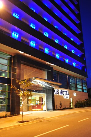 A modern hotel with a glass facade, illuminated blue lighting, and a prominent entrance. - Axis Porto Business & Spa Hotel (Matosinhos)