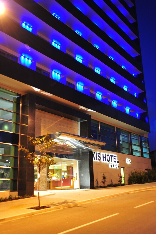 A modern hotel with a glass facade, illuminated blue lighting, and a prominent entrance. - Axis Porto Business & Spa Hotel (Matosinhos)
