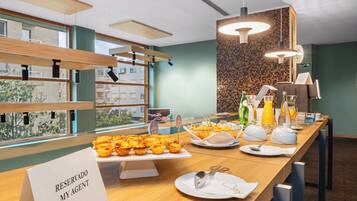 Un bufé de desayuno con diversos pasteles y un letrero que indica una zona reservada.