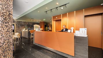 A reception desk with a receptionist, a check-in counter, and a seating area with chairs.