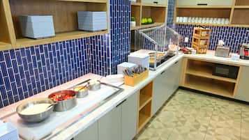 Uma mesa de buffet com diversos alimentos e utensílios.