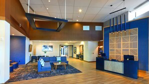 A spacious lobby with a reception desk, seating area, and a modern design.
