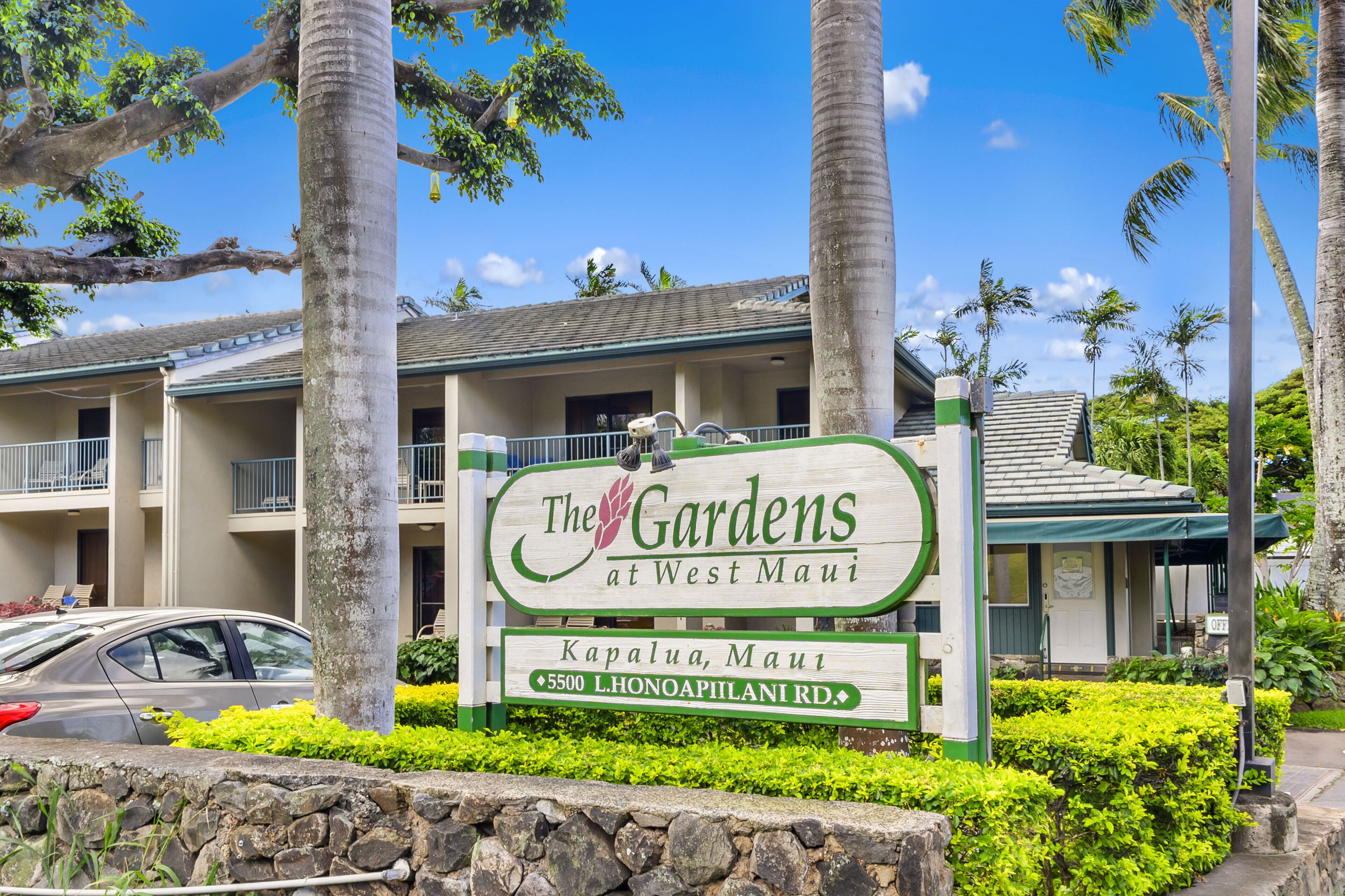 A hotel sign with "The Gardens at West Maui" and "Kapalua, Maui" along with the address "5500 L. Honoapiilani Rd."