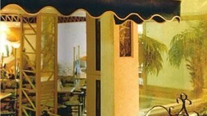 Un restaurant amb una tenda verda i la paraula "Harmon" escrita en ella.