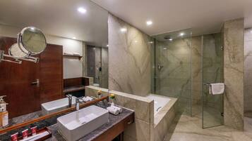 Un baño moderno con tocador doble, un espejo grande, ducha con cerramiento de vidrio y paredes de mármol.