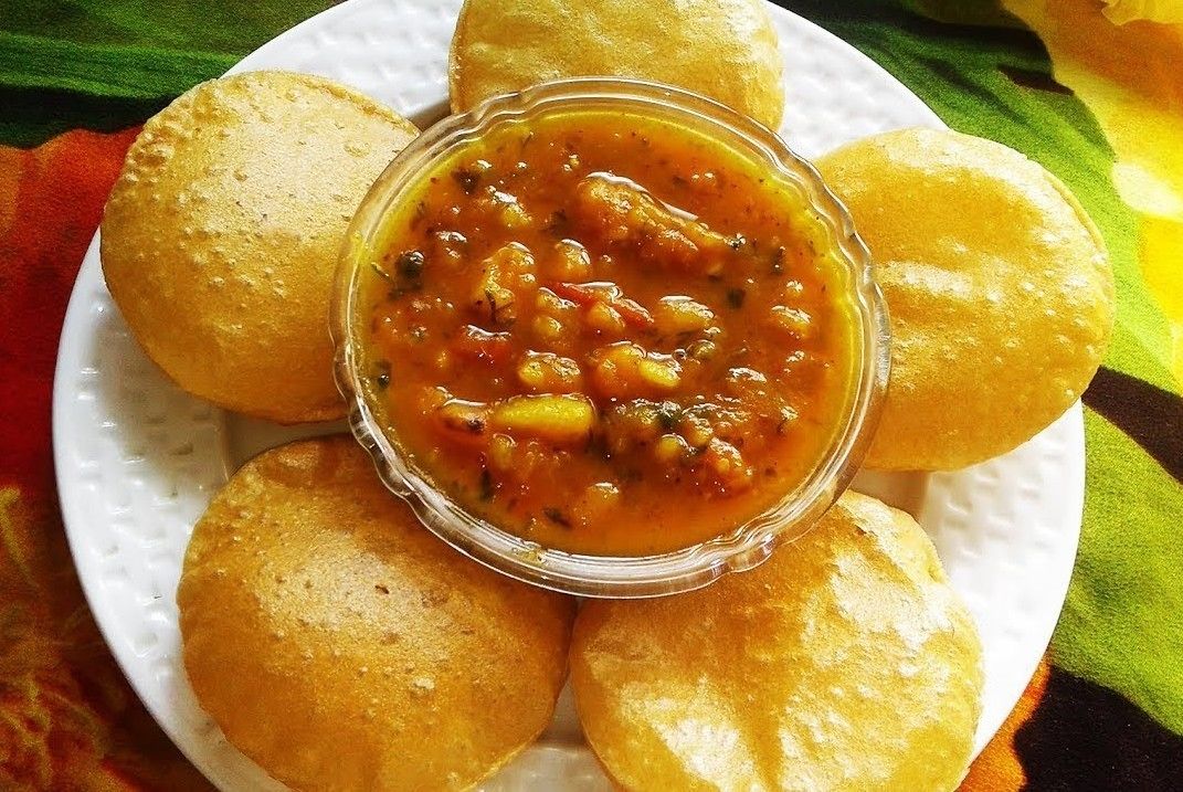 A plate of golden-brown fried items surrounded by a bowl of tomato-based sauce.