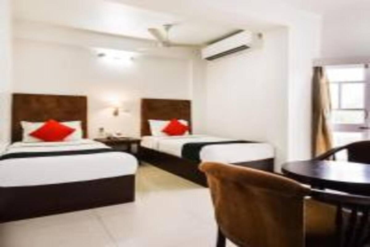Ein Hotelzimmer mit zwei Betten, einem kleinen Tisch und einem Stuhl.
