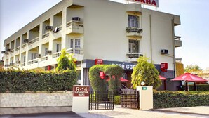 Un hotel llamado "HOTEL SHIKHA" con un letrero que indica "Café Coffee" y "R-14 YUDHISHTHIR MARG".