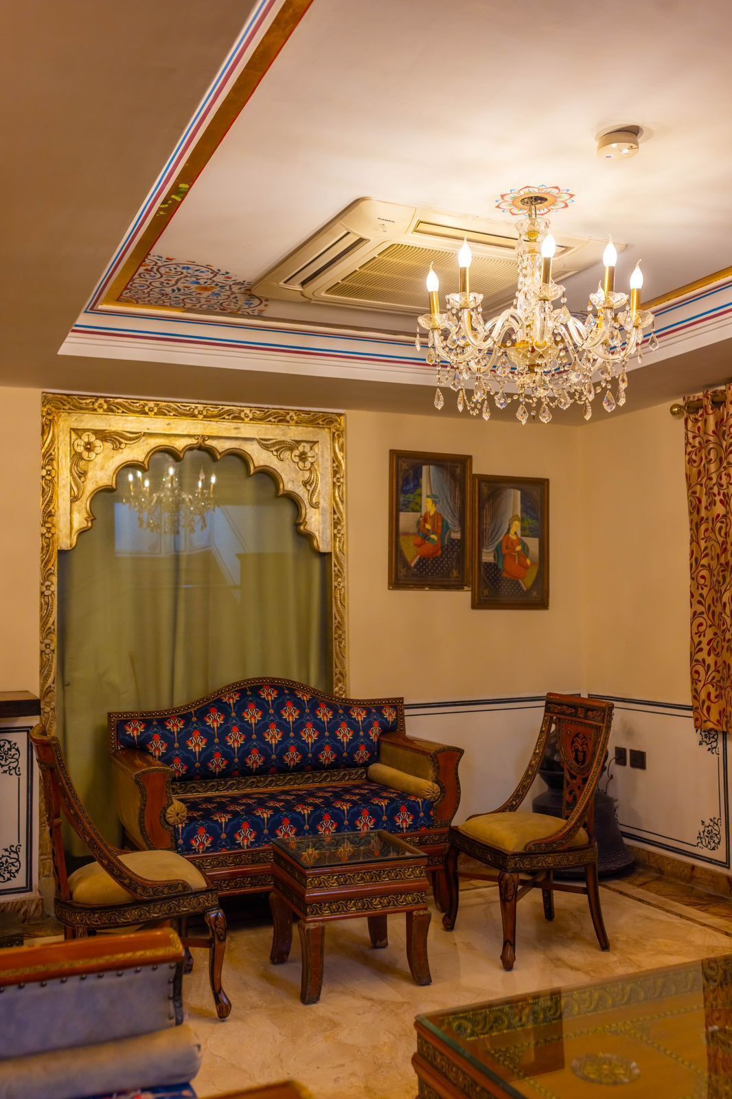 A traditional room with ornate furniture, a chandelier, and artwork on the walls.