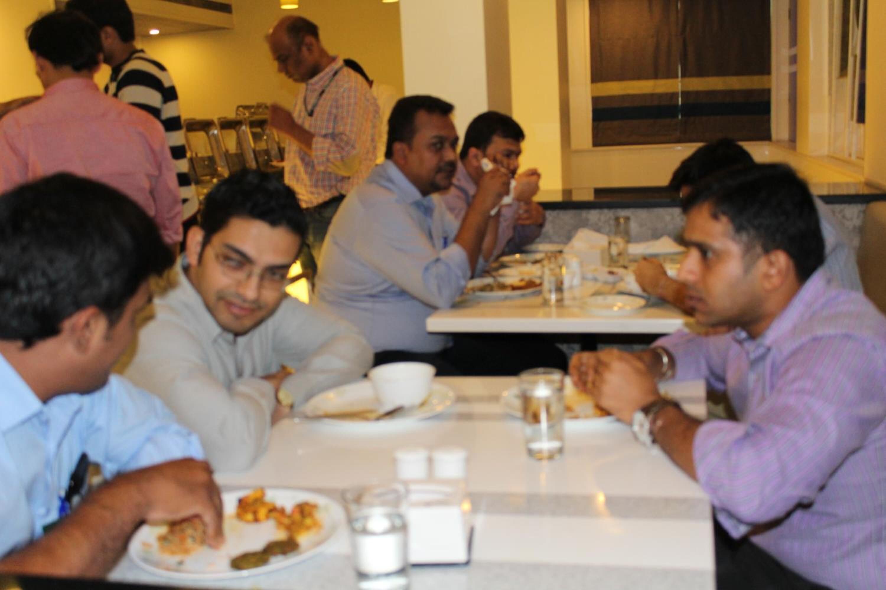 A group of people dining at a restaurant with tables and chairs.