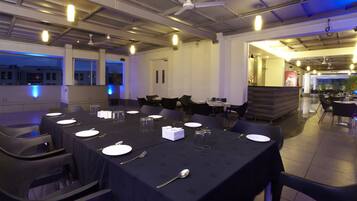 Un restaurant avec des tables dressées, des chaises et un ventilateur de plafond.