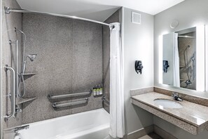 Une salle de bain moderne équipée d’une baignoire, d’une douche et d’un meuble-lavabo.