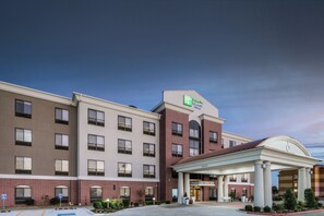 Un hotel Holiday Inn Express & Suites con fachada de ladrillo, múltiples ventanas y una entrada cubierta.