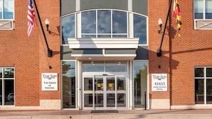 A brick building with large windows and a sign for The Inn at Park Avenue Hotel. - The Inn at Leonardtown, an Ascend Collection Hotel (Leonardtown)
