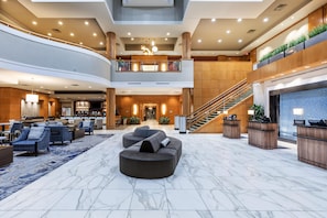 A spacious lobby with a bar area, seating, and a staircase.