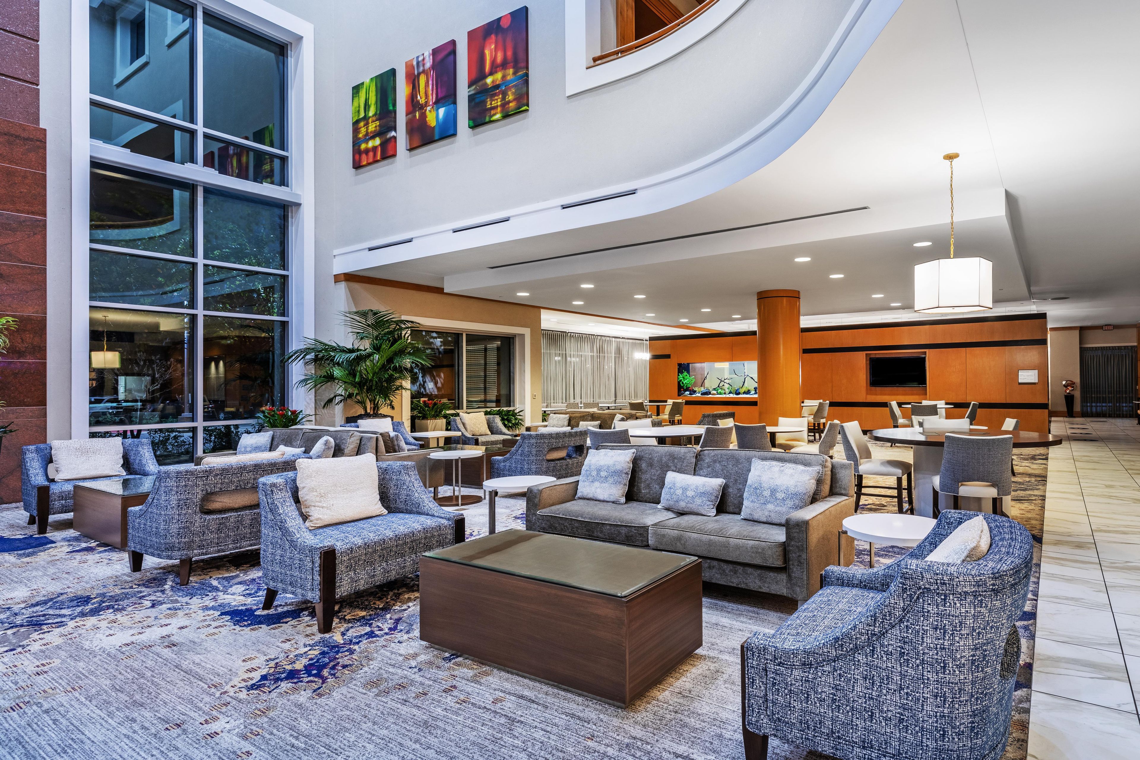 A spacious lobby with seating areas, a reception desk, and large windows.