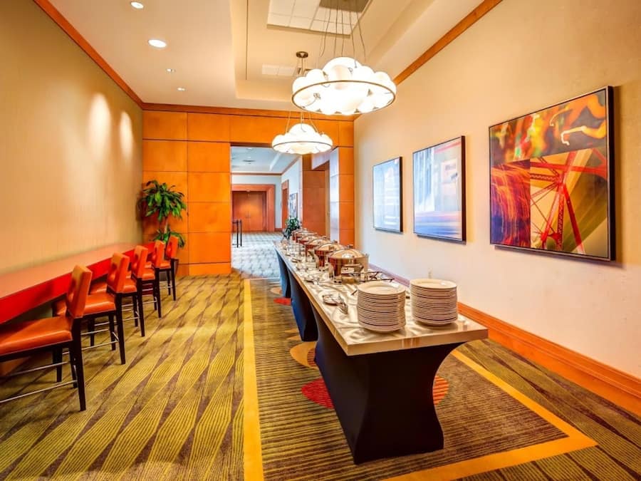 Un pasillo de hotel con una larga recepción, sillas y una mesa de buffet.
