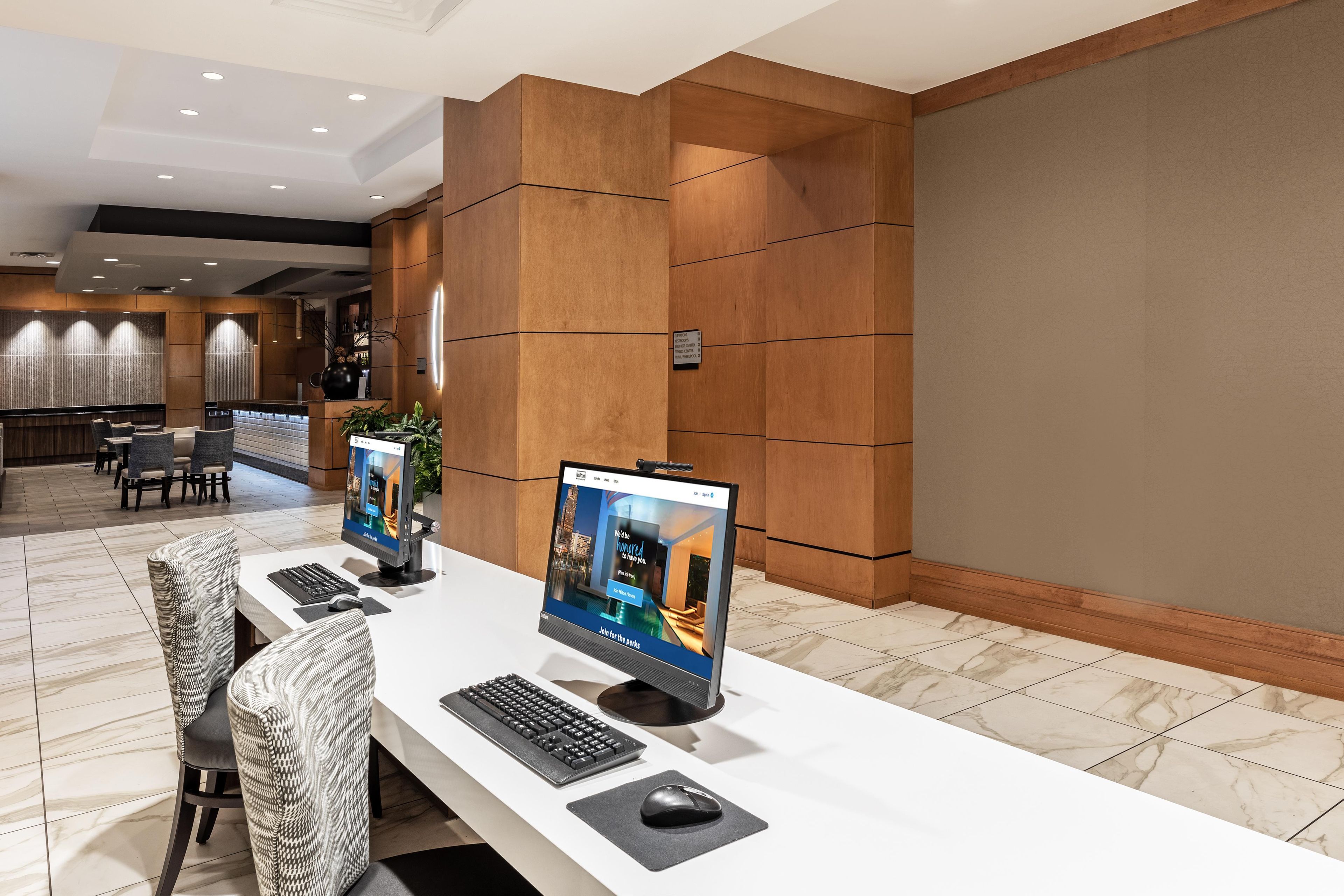 Un mostrador de recepción de hotel con dos monitores de computadora, un teclado y un ratón.