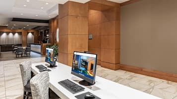 Un mostrador de recepción de hotel con dos monitores de computadora, un teclado y un ratón.