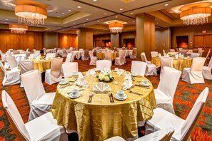 A banquet hall with round tables, white chairs, and chandeliers. - Embassy Suites by Hilton Houston Energy Corridor (Houston)
