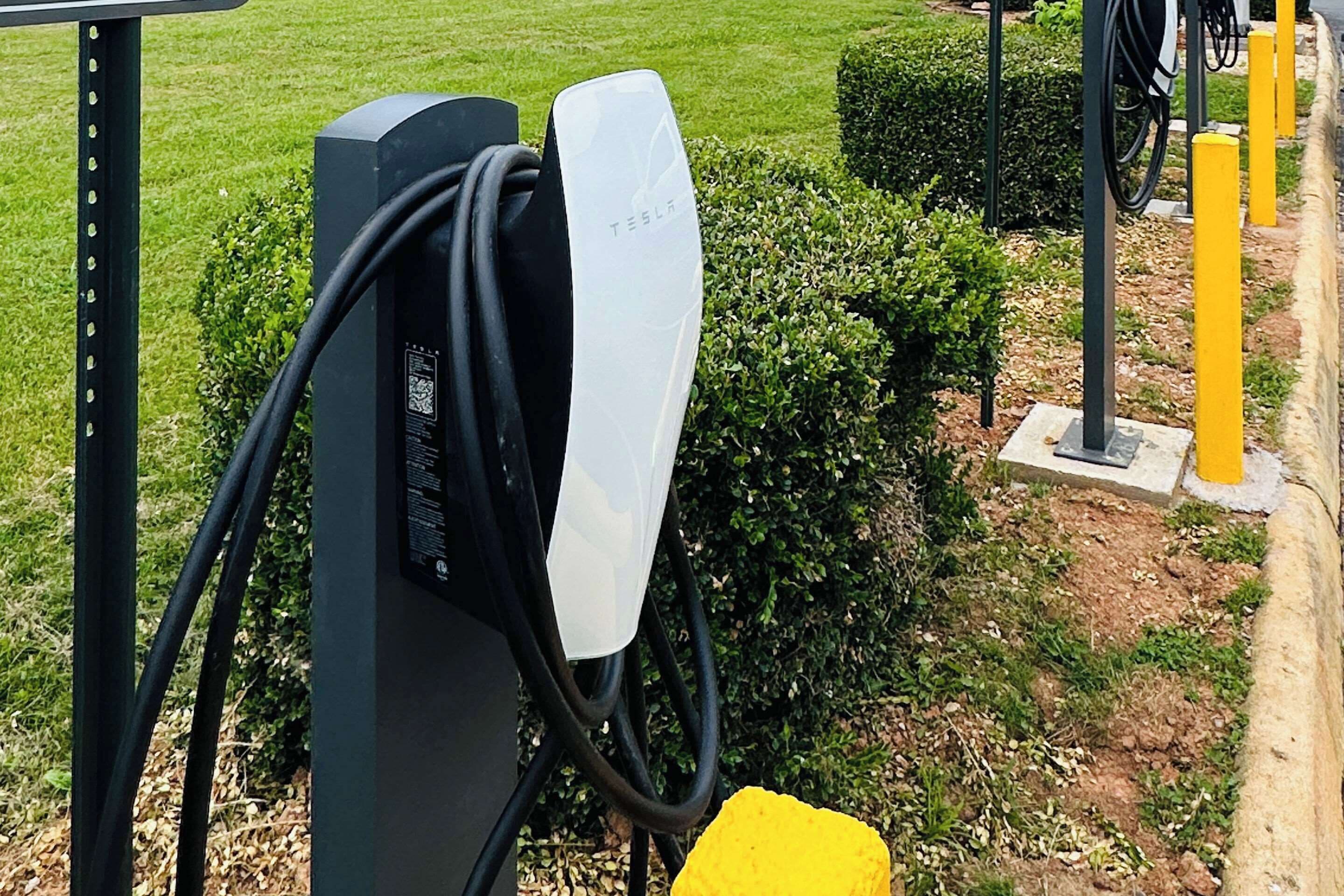 A Tesla charging station with a cable connected to a vehicle.
