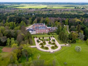 Vista aerea di una grande tenuta storica con ampi giardini e un design formale del prato.