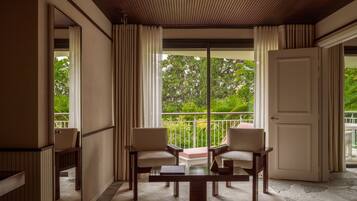 Ein Zimmer mit einem großen Fenster, zwei Stühlen, einem Tisch und einer Tür.