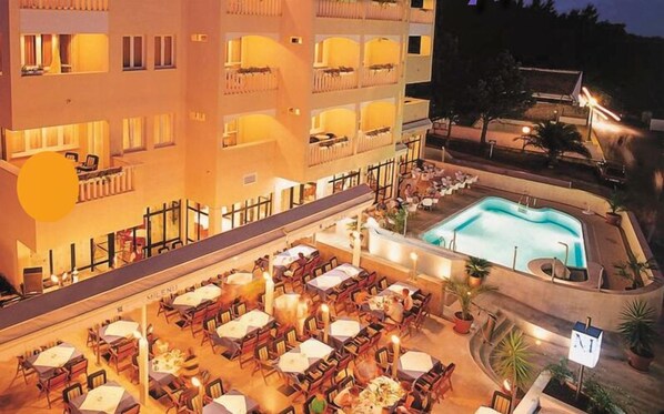 A hotel with outdoor dining and a swimming pool. - Aparthotel Milenij (Baska Voda)